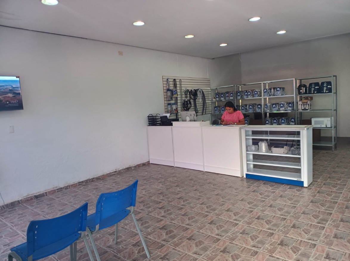 Interior da loja da Souza, com balcão de atendimento, prateleiras de peças e cadeiras de espera